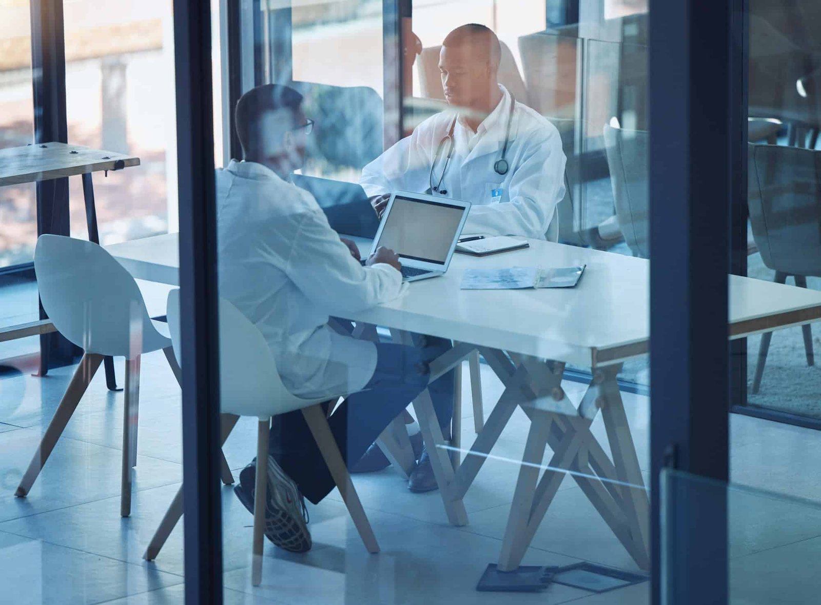Doctors, men and laptop in hospital meeting for surgery planning, insurance application or medical