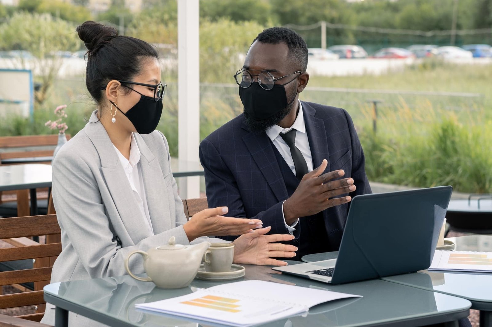 Two young brokers discussing materials for presentation