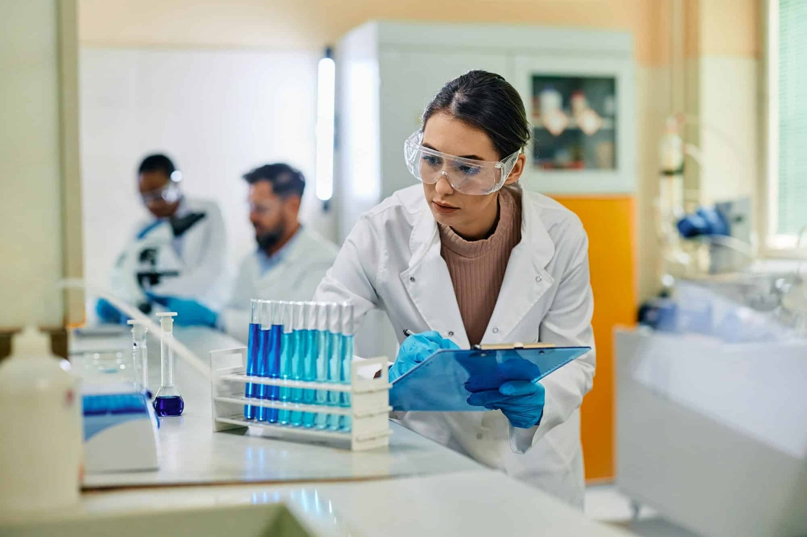 Young female scientist analyzing chemical substances in test tubes in a lab.